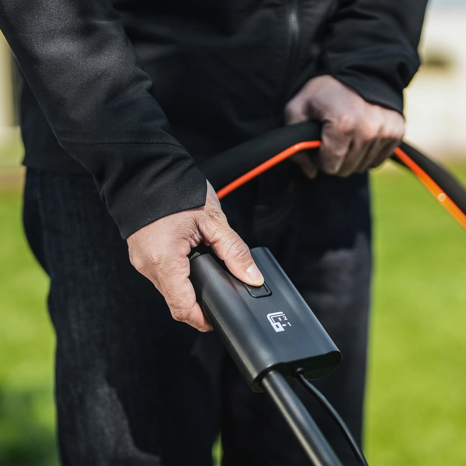 Bedienung des Litheli U20 Akku-Rasenmähers: Hand am Griff mit Startknopf.