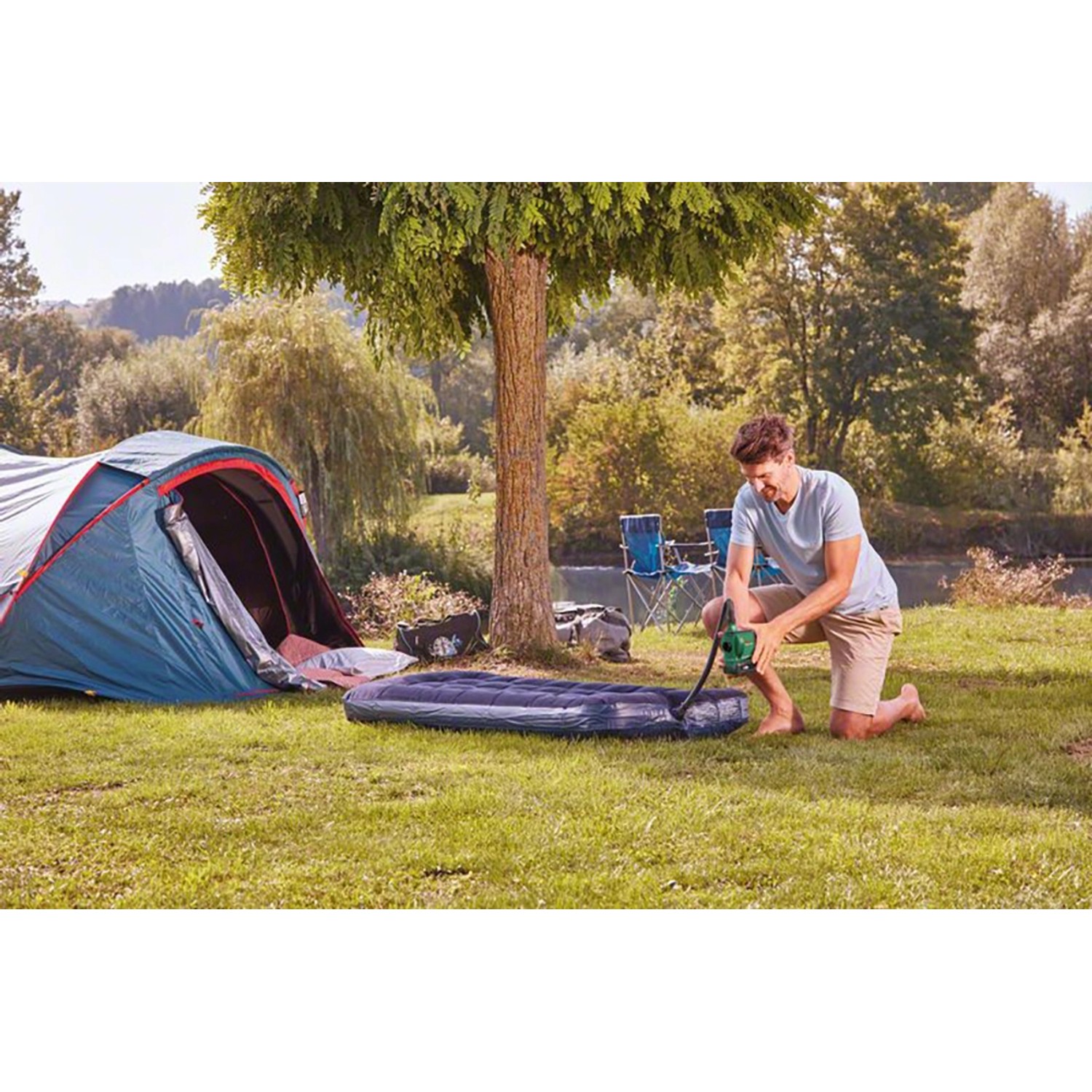 Mann pumpt Luftmatratze mit Bosch Akku-Luftpumpe EasyInflate 18V-500 Solo auf Campingplatz auf.