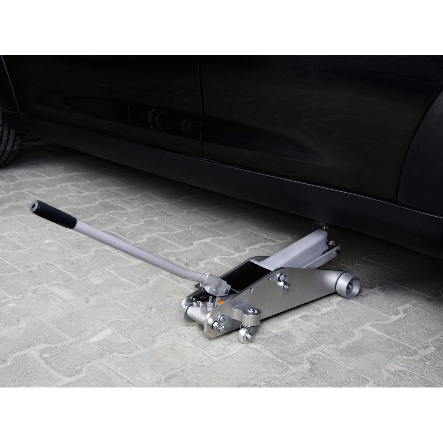 OBI Rangierwagenheber 2,25 t unter Auto. Wagenheber aus Stahl/Aluminium mit Rädern und Hebel.