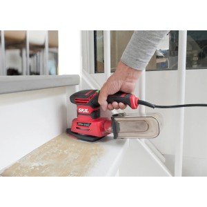 Skil Multischleifer 7280DA in Aktion beim Schleifen einer Treppenstufe. Rotes Gehäuse, Staubfangbehälter.