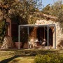Anthrazitfarbene Eleo Pergola Ischia aus Metall, 252,2 x 308 x 204 cm, vor einem Haus mit Tisch und Stühlen.
