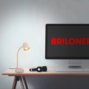 Beige Brilo Tischleuchte Skriva aus Metall mit flexiblem, schwenkbarem Kopf auf Schreibtisch. Moderne Schreibtischlampe für Arbeitsplatz.