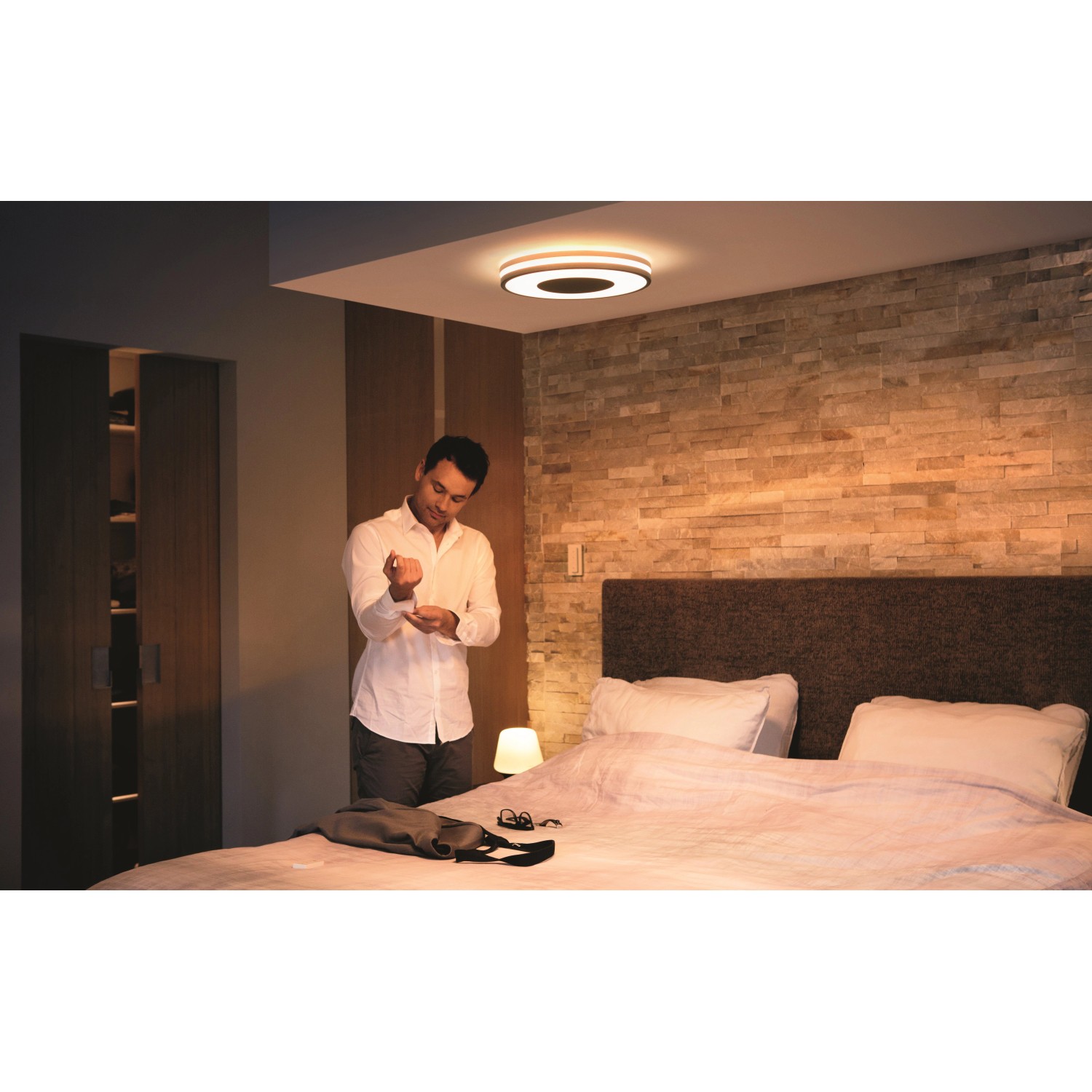 Schwarze Philips Hue Being Deckenleuchte mit Dimmer im Schlafzimmer.