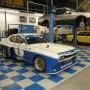 Verlegtes Schachbrettmuster mit Florco Kunststoff-Klickfliesen in Weiß-Alu und Blau in einer Werkstatt mit Autos.