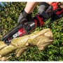 Skil Akku-Astsäge 0514CA in Aktion, schneidet Ast. Rot-schwarze Akku-Kettensäge mit 15 cm Schwertlänge.