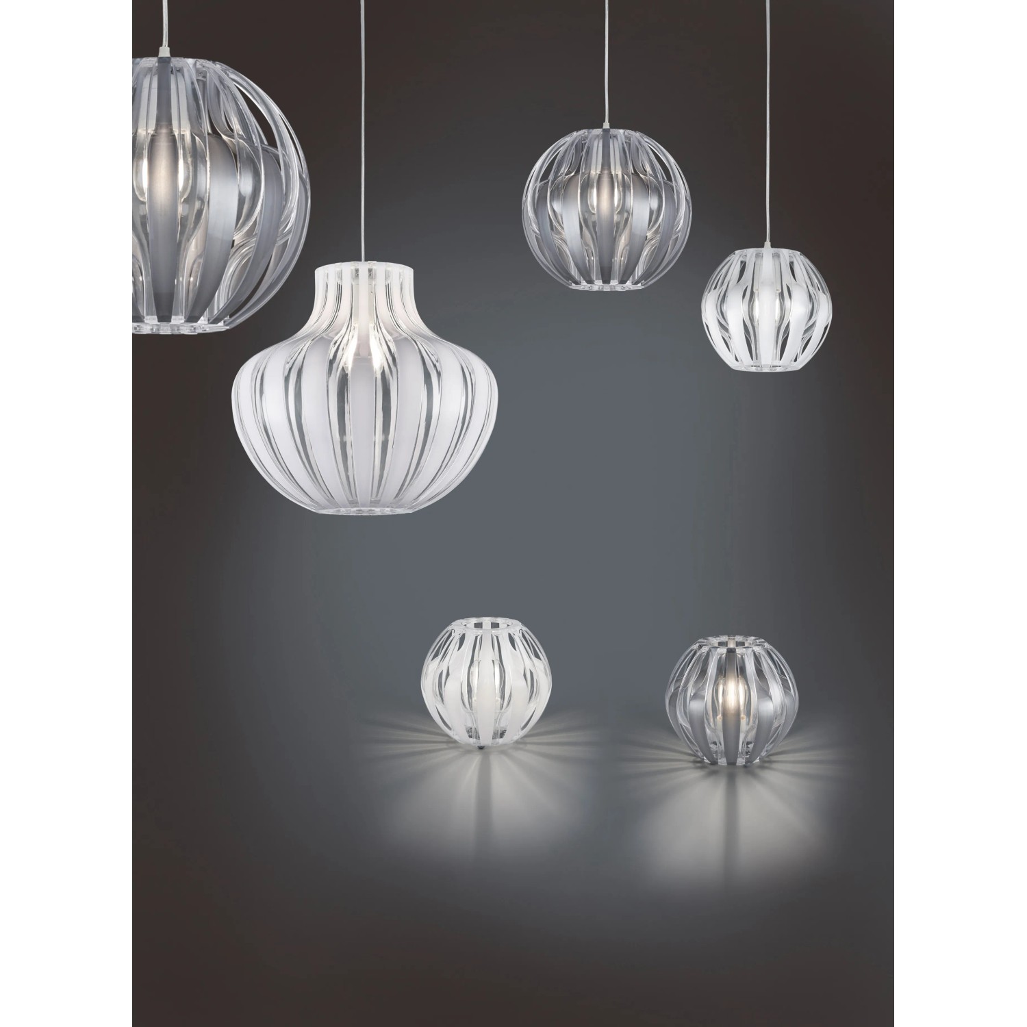 Mehrere Trio Pendelleuchten Pumpkin, weiß und transparent, in verschiedenen Formen und Größen.