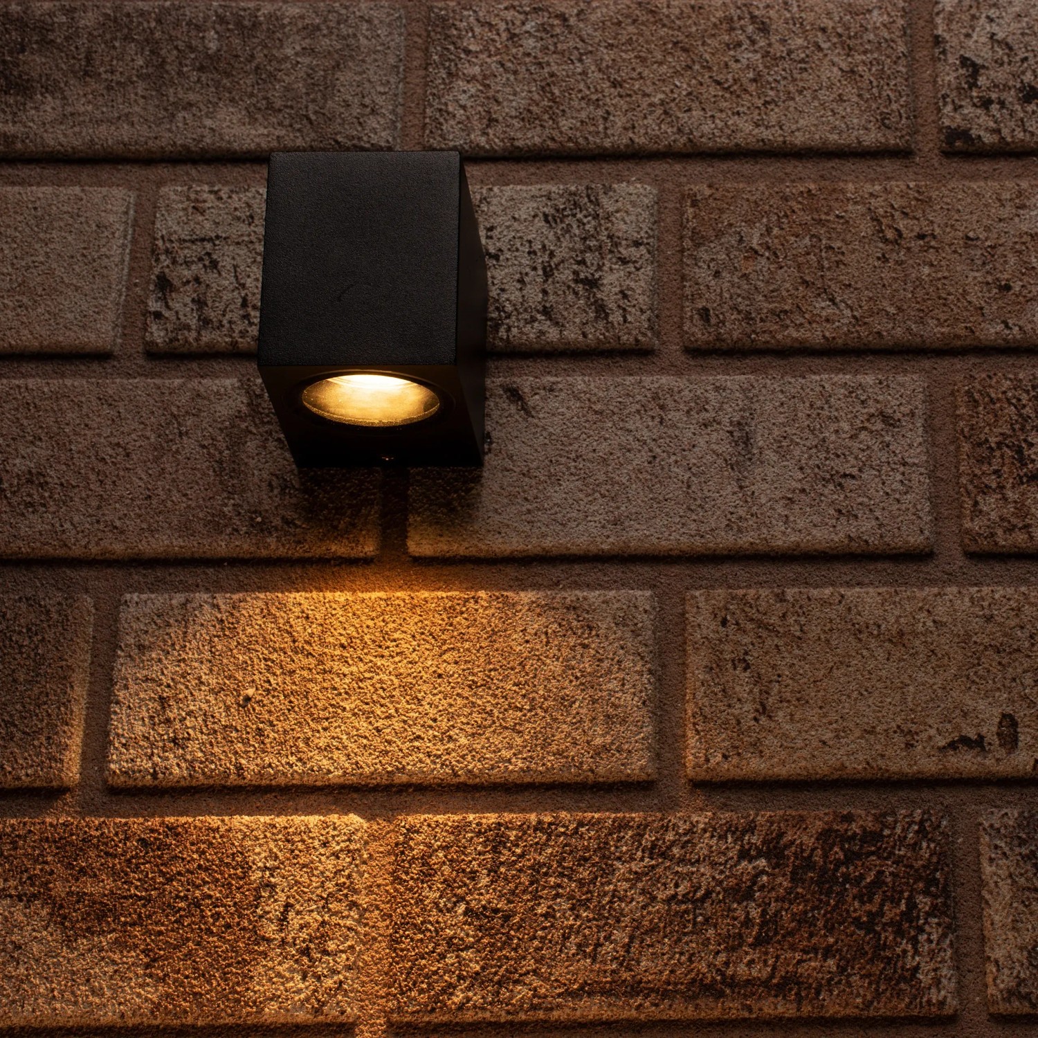 Schwarze, eckige LED`s light Außenwandleuchte an einer Backsteinwand.