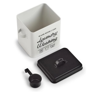 Weiße Waschpulverbox aus Metall mit schwarzem Deckel und Dosierlöffel.
