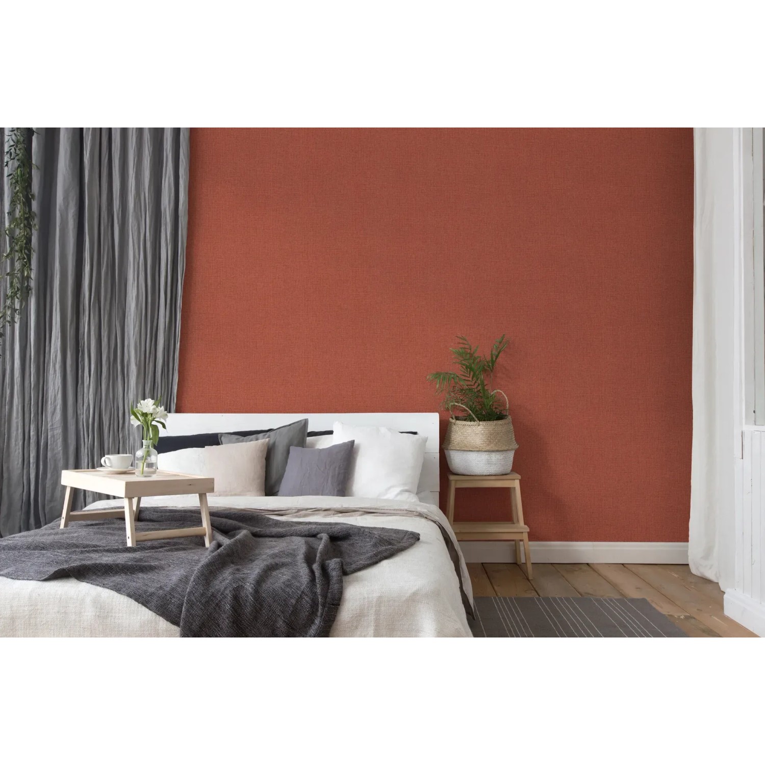 Schlafzimmer mit roter Vliestapete Uni, leicht strukturiert und matt.