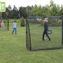 Schwarzes EXIT Coppa Fußballtor (220x170cm) mit Trainingswand im Garten.