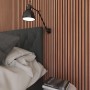 Akustikpaneel Mahagoni an Wand hinter Bett mit Lampe. Holzpaneel für bessere Raumakustik.