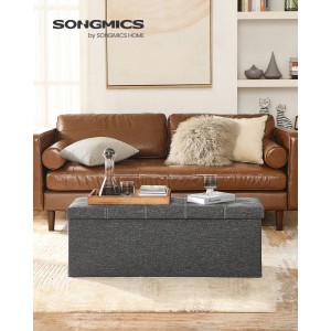 Graue Songmics Sitzbank mit Stauraum (110x38x38 cm) vor braunem Sofa im Wohnzimmer.