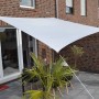 Hell silbergraues Floracord Vierecksonnensegel (250x300cm) über einer Terrasse mit Gartenmöbeln.