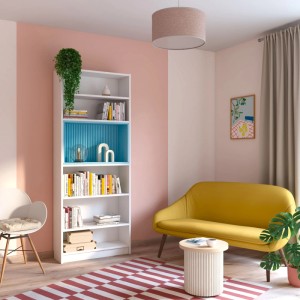 Wohnraum mit rosa Wand, Regal, gelbem Sofa und gestreiftem Teppich.