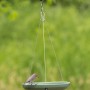 Hängende, grüne CJ Wasserschale Vesi als Vogeltränke mit Vogel im Garten.