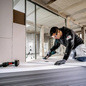 Metabo Akku-Multitool MT 18 LTX Compact Solo im Einsatz beim Sägen einer Gipskartonplatte.