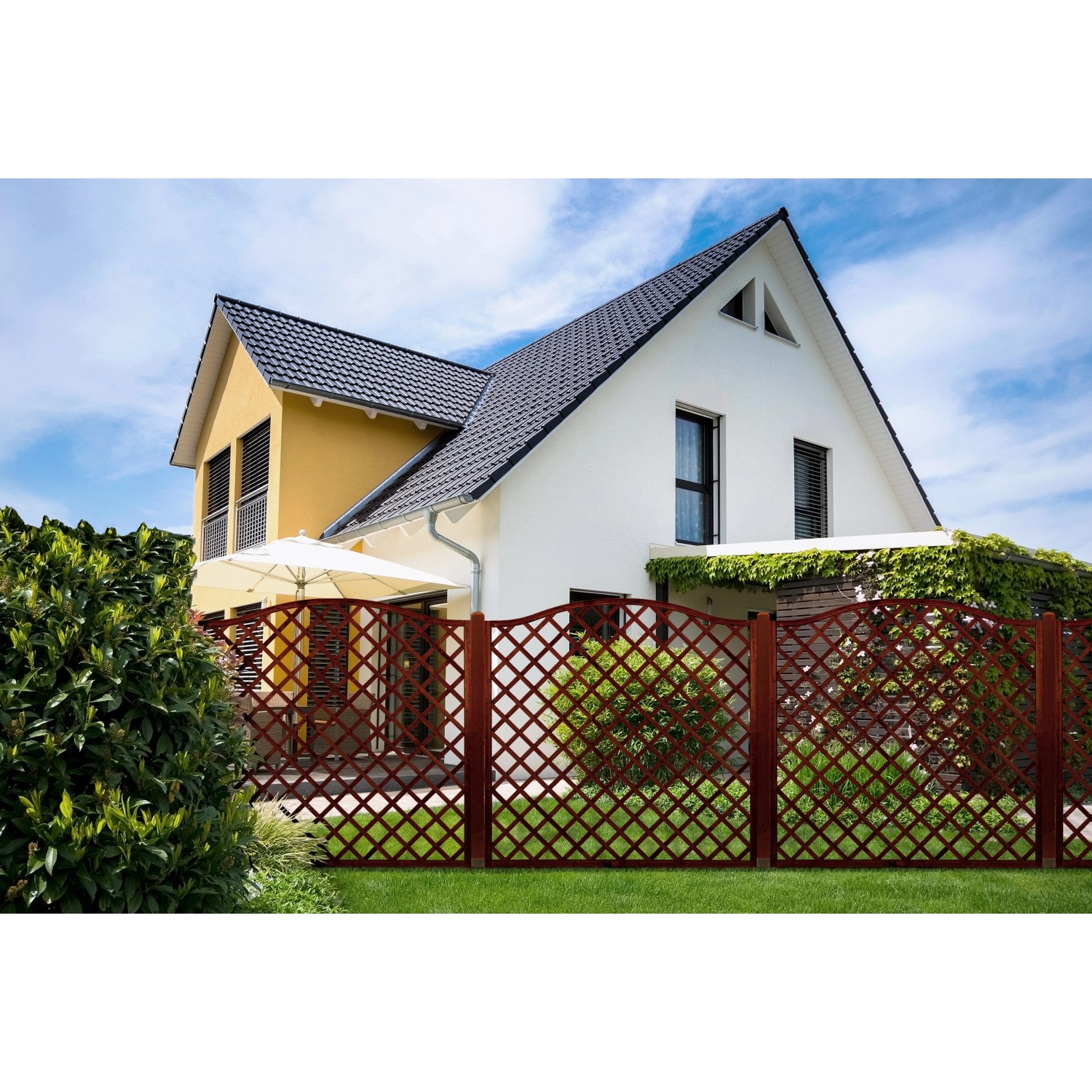 Braunes Sichtschutzzaun-Element Nancy (180x90cm) aus Kiefernholz im Garten vor einem Haus.