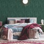 Schlafzimmer mit dunkelgrüner A.S. Création Vliestapete in Rostoptik und leichtem Glanz.