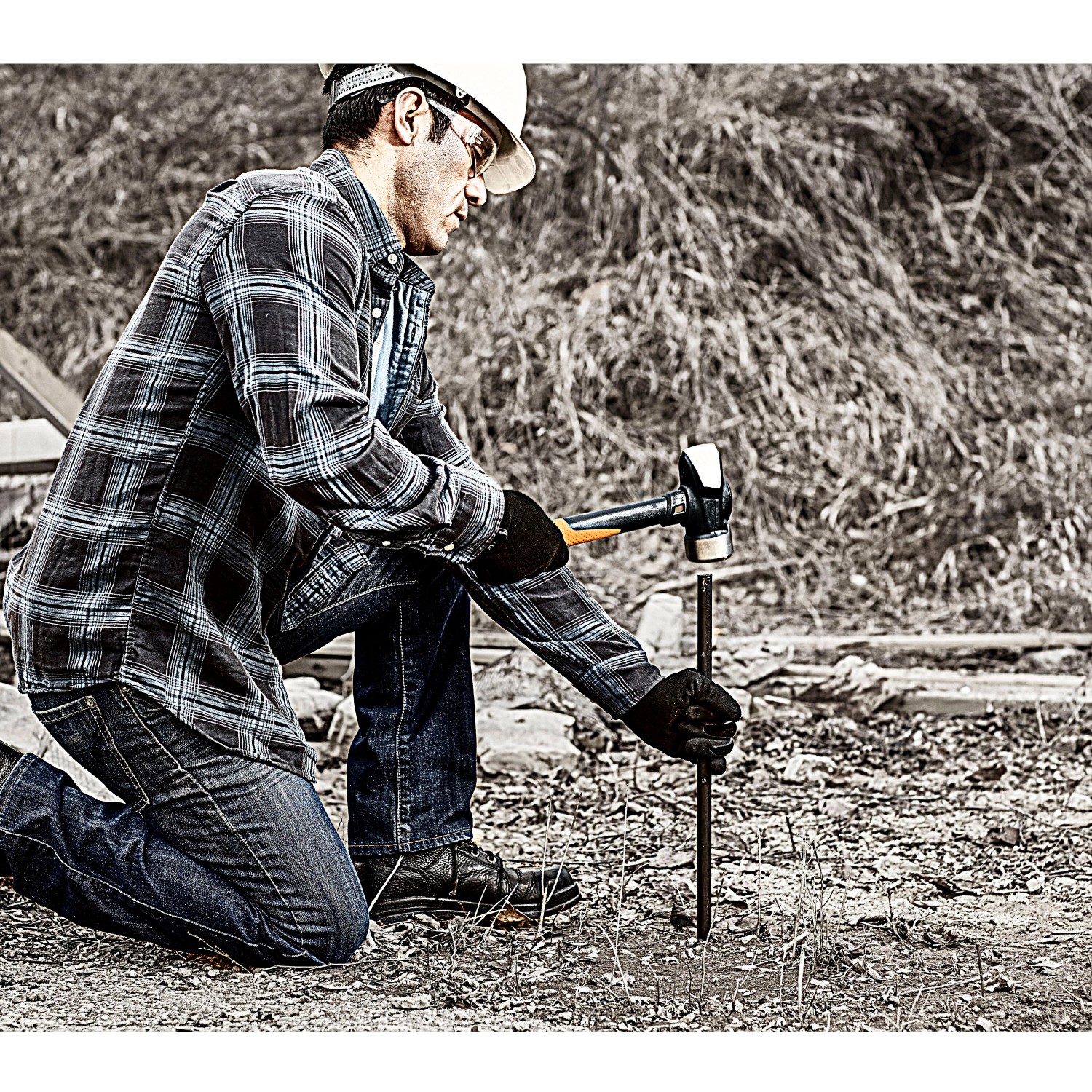 Mann treibt mit Fiskars Fäustel IsoCore L einen Erdanker in den Boden. Kategorie: Bodenbearbeitung.