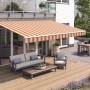 Wismar Gelenkarmmarkise Classic, 300x200 cm, beige-rot gestreift, über einer Terrasse mit Gartenmöbeln.