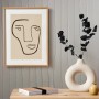 Moderne Vliestapete in Creme mit abstraktem Gesicht-Motiv im Bilderrahmen an der Wand.