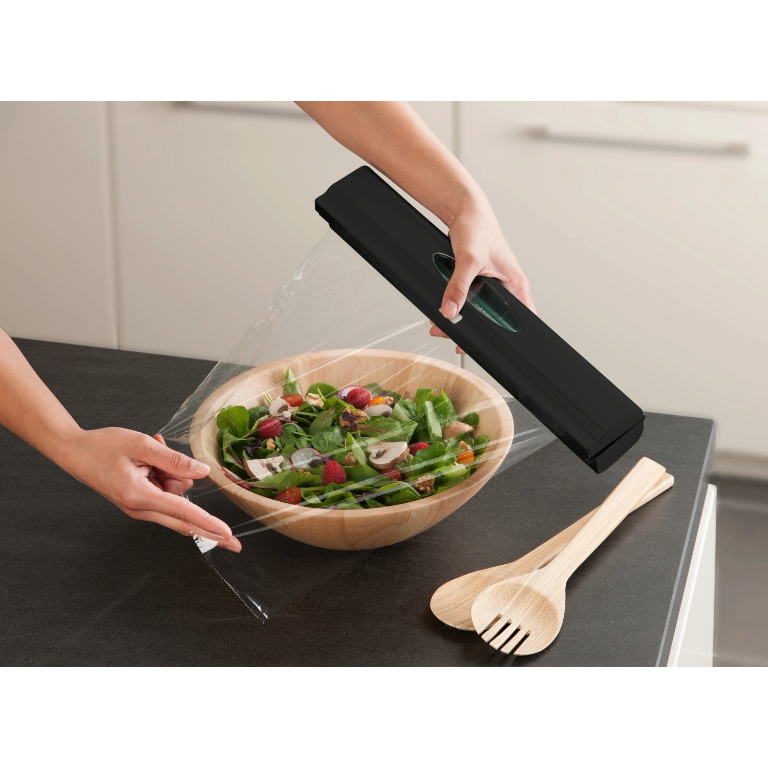 Wenko Folienspender Perfect Cutter Black Outdoor Kitchen beim Abdecken einer Salatschüssel.