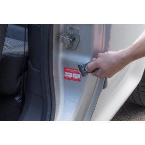 Wolfcraft Schaber mit Kunststoffklingen im Einsatz zum Entfernen eines Aufklebers von einer Autotür.