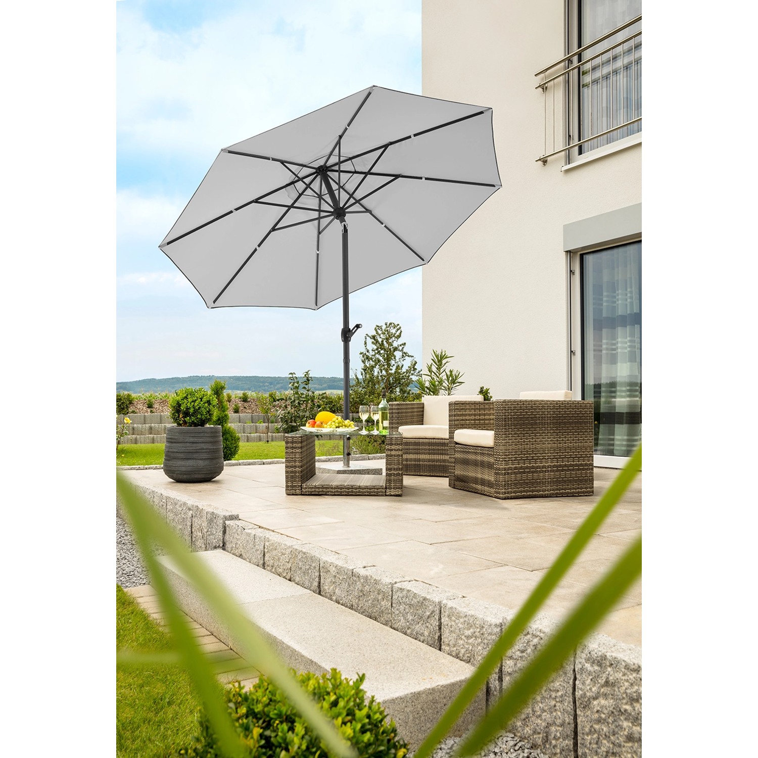 Silbergrauer Schneider Marktschirm (Ø 300 cm) mit Knickfunktion auf Terrasse mit Gartenmöbeln.