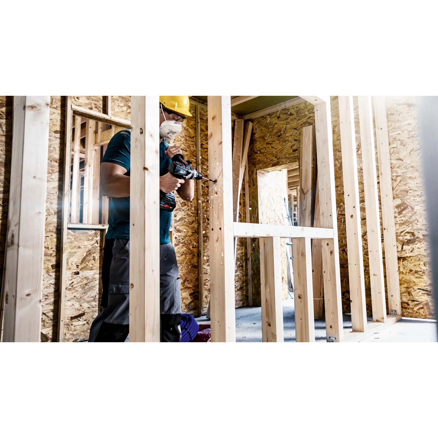 Handwerker bohrt mit Bosch Flachfräsbohrer Expert Self Cut Speed ein Loch in eine Holzwand.