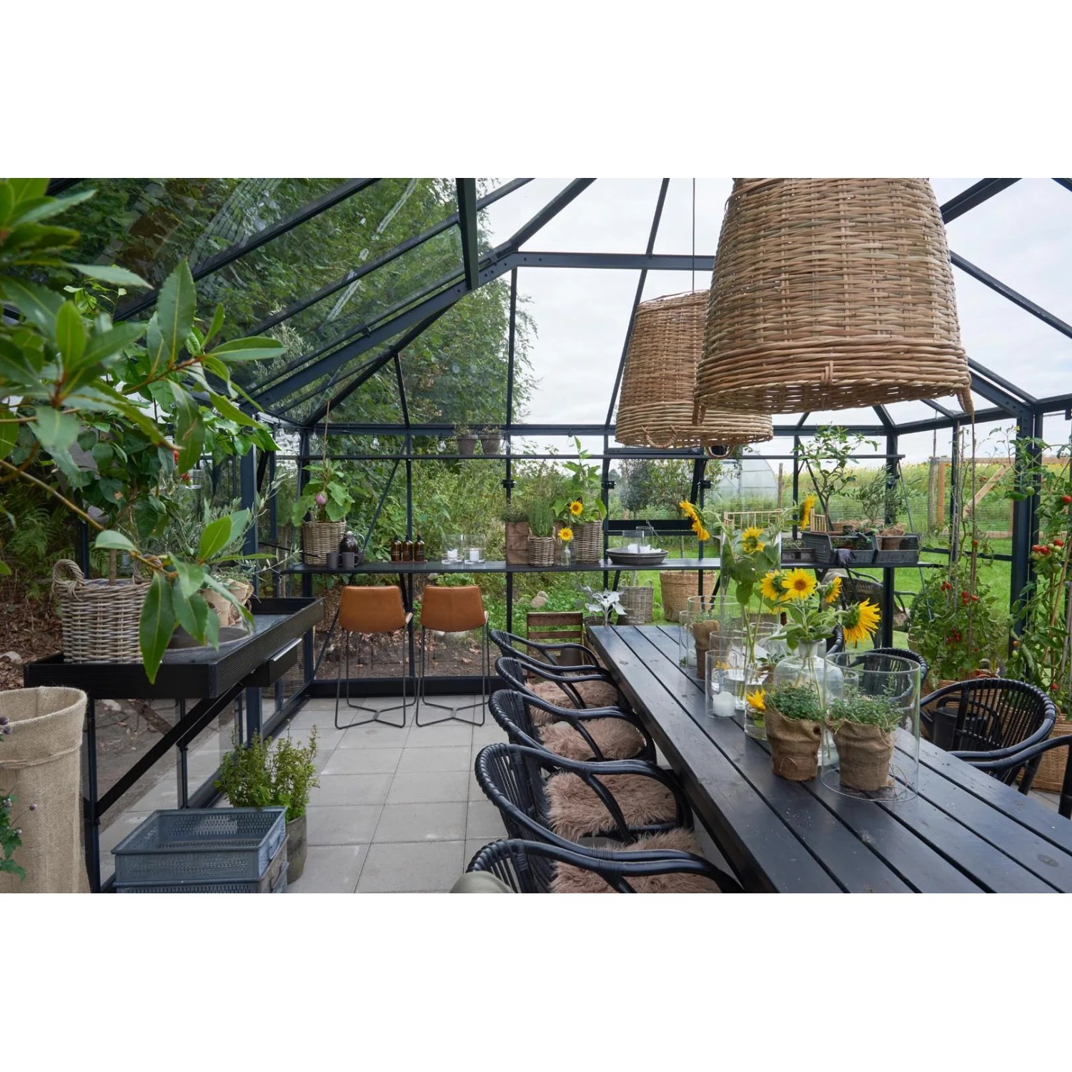 Innenansicht: Juliana Gewächshaus Grand Oase 25, schwarz-anthrazit, mit Tisch und Stühlen dekoriert.