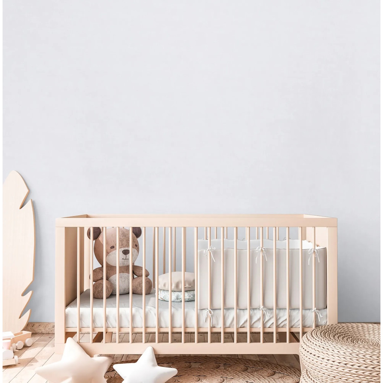 Kinderzimmer mit weißer Uni Vliestapete von A.S. Creation hinter einem Babybett.