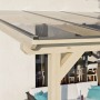 Skan Holz Terrassenüberdachung Andria aus Leimholz mit klarer Polycarbonat-Eindeckung.