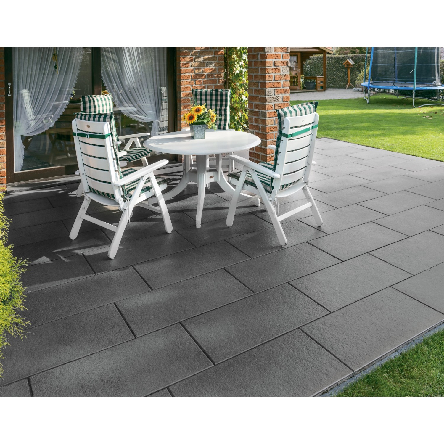 Diephaus Terrassenplatten Finessa in Schwarz-Basalt, 80x40 cm, auf einer Terrasse mit Gartenmöbeln.