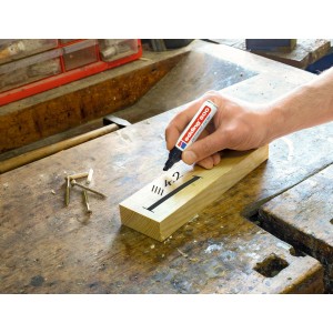 Hand schreibt mit schwarzem Edding 500 Permanent Marker auf Holz.