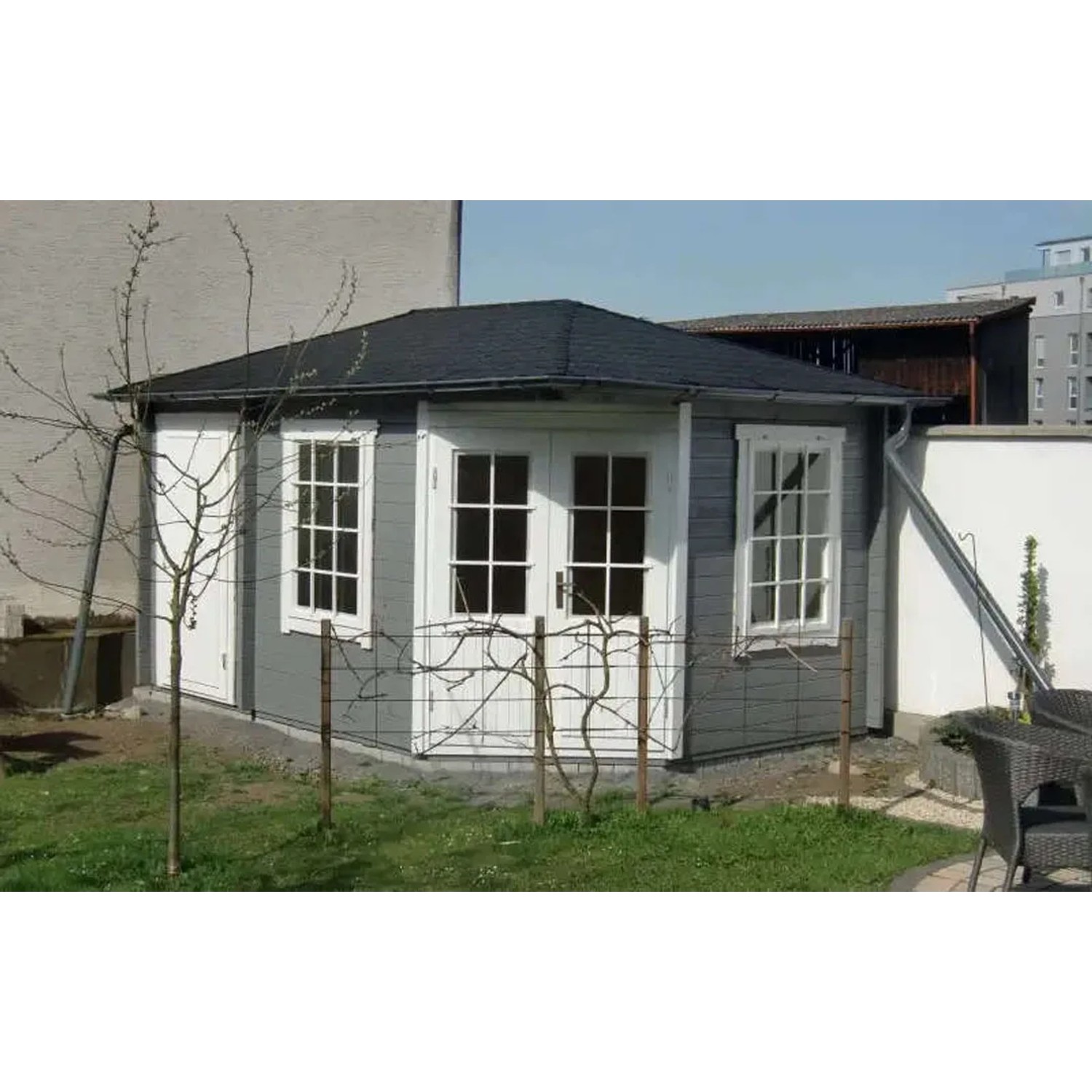 Unbehandeltes Alpholz Gartenhaus Rhein mit Walmdach, grau gestrichen, mit weißen Fenstern und Türen.