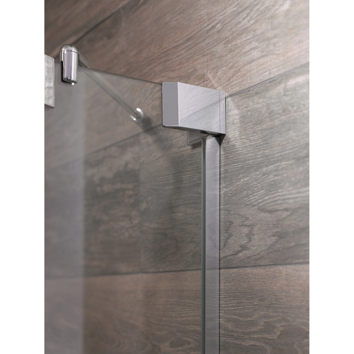 Detailaufnahme: Chromfarbene Dusch-Nischentür Brava mit Festteil und klarem Glas.