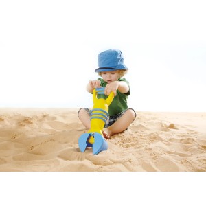 Kind mit gelbem Hape Sandspielzeug Greifer im Sandkasten.