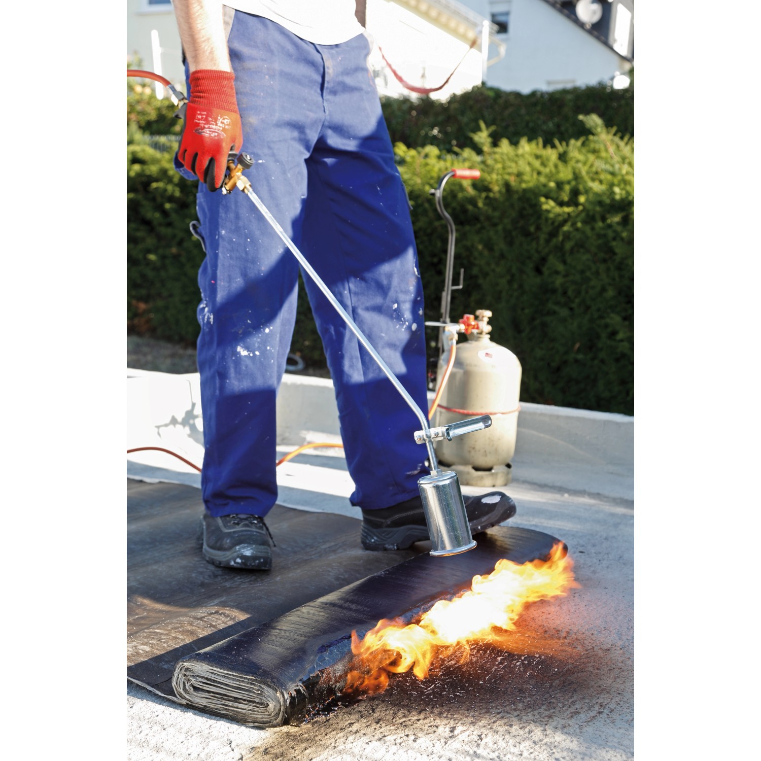 Anwender beim Verschweißen von Bitumenbahnen mit dem Rothenberger RoMaxi Anwärmbrenner Set.
