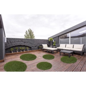 Andiamo Kunstrasen, runde grüne Rasenteppiche auf einer Holzterrasse mit Gartenmöbeln.