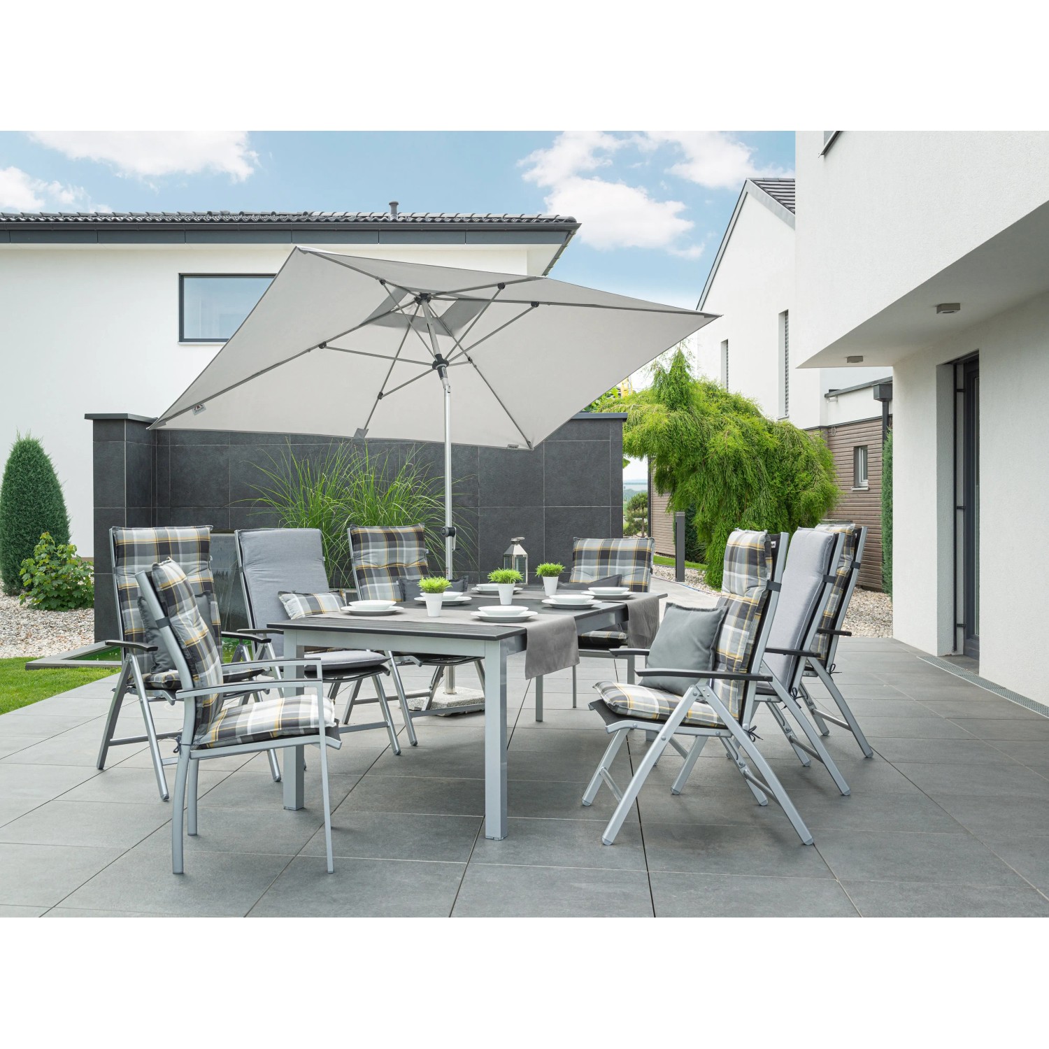 Grauer Doppler Marktschirm Expert 200x300 cm mit Knickfunktion über einer Gartengarnitur.