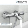 Schütte Thermostat Wannenarmatur London Chrom mit Wasserstrahl vor Fliesenwand.