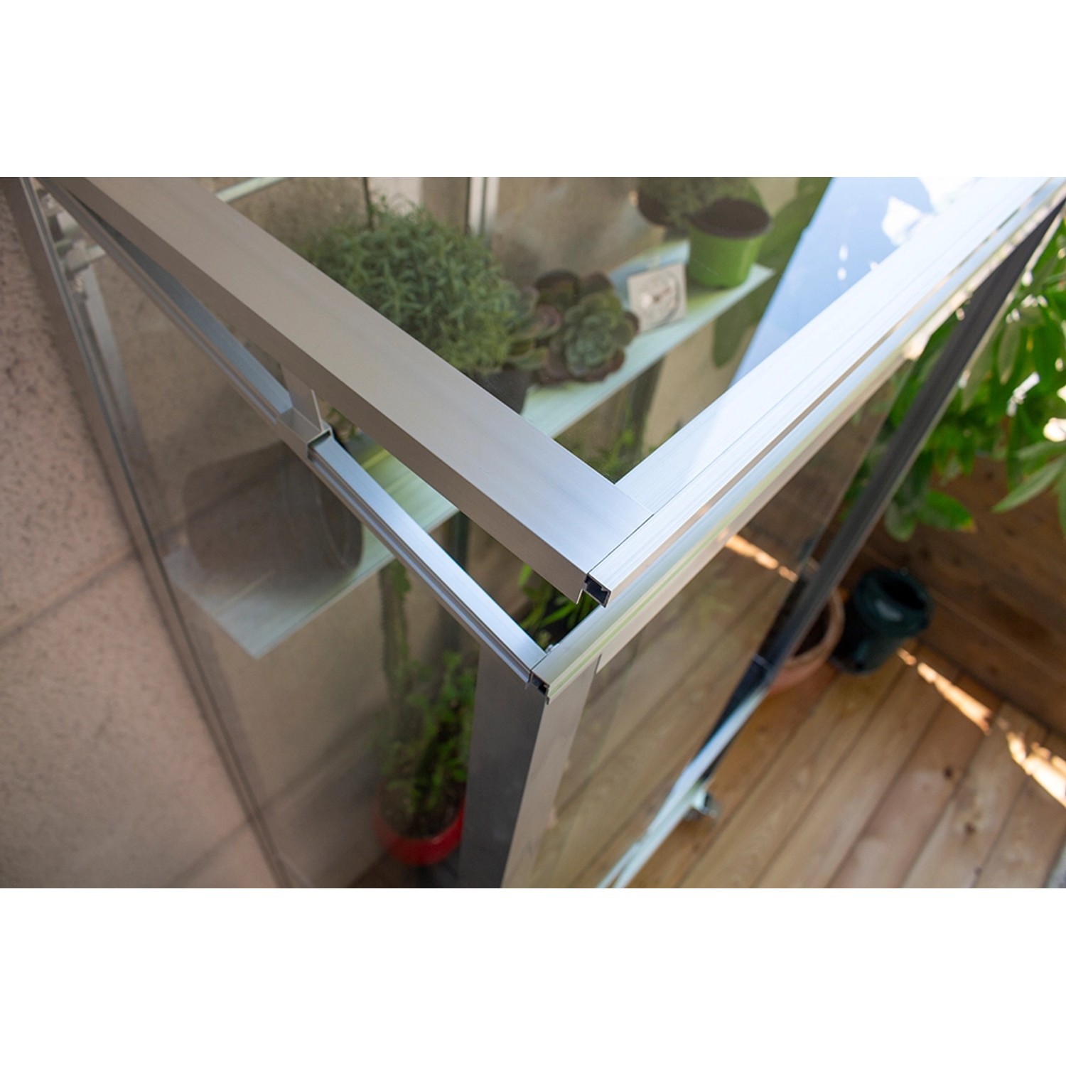 Detailaufnahme des Vitavia Polis Balkongewächshauses mit Alu-Rahmen und Pflanzen.