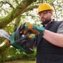 Mann sägt Ast mit Bosch Akku-Kettensäge UniversalChain 18. Kompakte Akku Kettensäge für Gartenarbeiten.