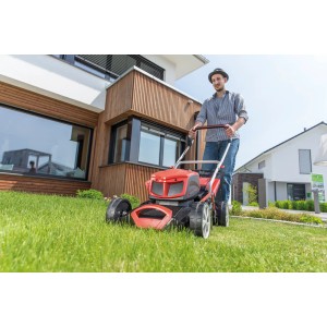 Al-Ko Akku-Rasenmäher 42.9 LI: Mann mäht Rasen vor modernem Haus. Inkl. Akku und Ladegerät.