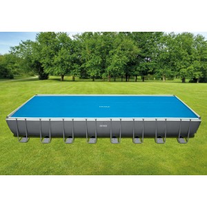 Rechteckiger Intex Ultra Frame Pool mit blauer Solarplane 975x488 cm im Garten.