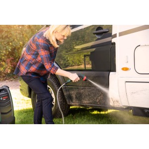 Frau reinigt Wohnmobil mit Bosch Akku-Druckreiniger Fontus 18V. Mobiler Hochdruckreiniger im Einsatz.