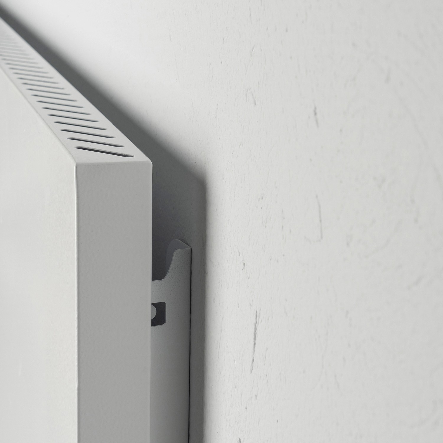 Detailaufnahme: Weiße Vasner Konvi RX Infrarotheizung an Wand montiert.