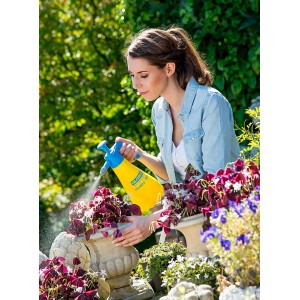 Frau benutzt gelbes Gloria Drucksprühgerät Hobby 100 zur Pflanzenpflege.