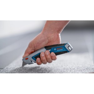 Bosch Professional Universal Teppichmesser im Einsatz, schneidet Teppich.