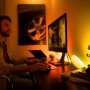 Szene mit Philips Hue Go Tischlampe: Gamer am PC mit stimmungsvoller Beleuchtung.